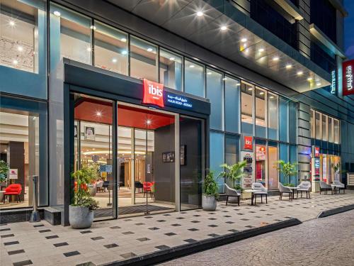 a store front of a building with tables and chairs at Ibis Jeddah Malik Road in Jeddah