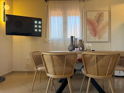 a dining room with a table and chairs and a television at Mersea deluxe apartment Kourouta in Kourouta