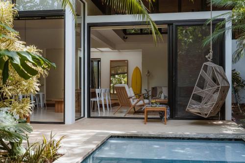 a house with a swimming pool and a patio at Nalu Nosara Pool Villa Flor in Nosara