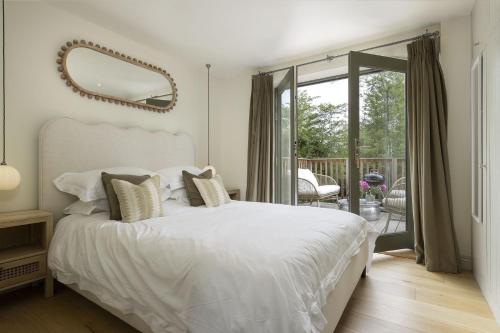 a bedroom with a white bed and a mirror at The Old Workshop, Combrook in Combrook