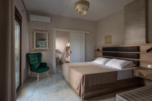 a bedroom with a bed and a green chair at Tsamakdas House in Toroni