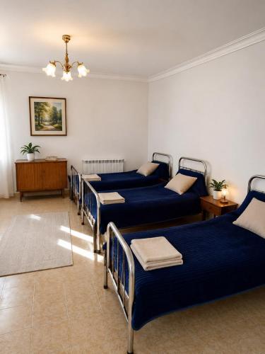 a room with four blue beds in a room at Гостевой дом Москва in Aktobe