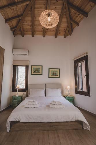 a bedroom with a large bed and two windows at Calliοpe's home in Skiathos