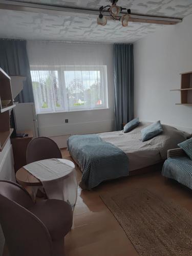 a bedroom with two beds and a table and a window at Dom Wczasowy Jędrek pokoje in Niechorze