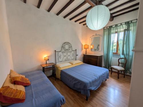 a bedroom with two beds and a mirror at La Francigena in Staggia