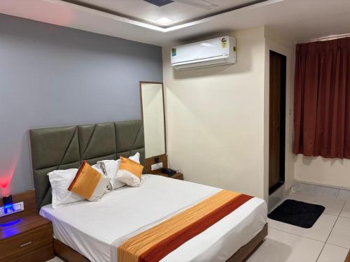 a bedroom with a bed and a air conditioner at Hotel Sunrise View in Ahmedabad