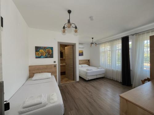 a bedroom with a bed and a bathroom with a tub at Parli Hotel in Gokceada Town