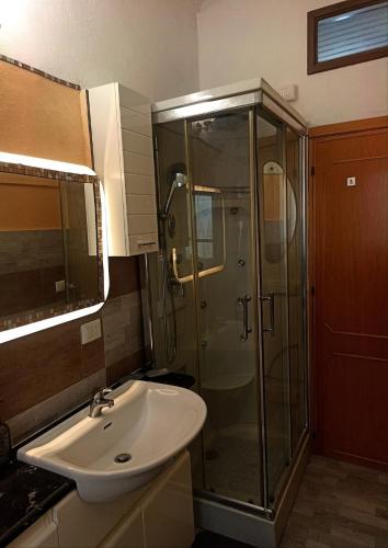 a bathroom with a sink and a glass shower at Collina Blu in Cuglieri