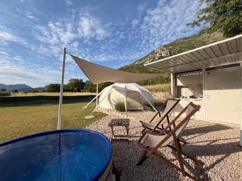 a tent and a couple of chairs and a table at Lisinj Sky Glamping in Bar