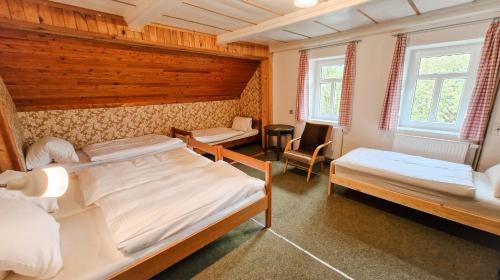 a bedroom with two beds and a table and chairs at Chalupa Šumburk in Svárov