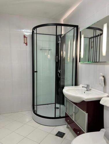 a bathroom with a glass shower and a sink at Hotel Bistrita in Bacău