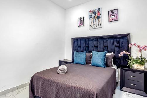 a bedroom with a large bed with blue pillows at Dog-friendly home 3 rows to beach with rooftop deck, pool, hot tub, & kitchen in Rosarito