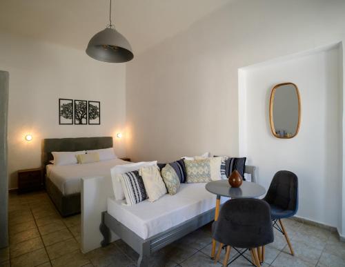 a bedroom with a bed and a couch and a table at Kamares Neoklassiko in Fira