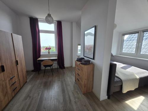 a bedroom with a bed and a dresser and a mirror at Der Stader Fernblick in Stade