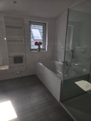 a white bathroom with a tub and a window at Der Stader Fernblick in Stade