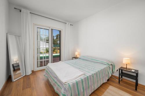 a bedroom with a bed and a large window at Casa Sol in Praia do Carvoeiro