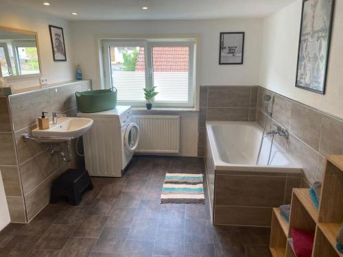a bathroom with a tub and a sink and a bath tub at NEU! Ferienwohnung Bruno in Gersfeld