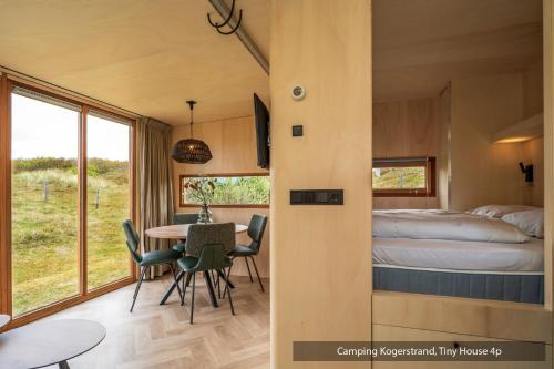 a room with a bed and a table and chairs at Texelcampings - Kogerstrand in De Koog