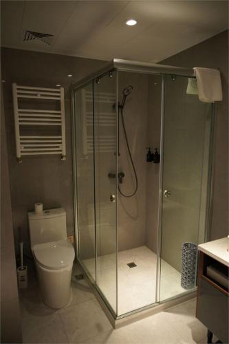 a bathroom with a glass shower with a toilet at Happiness Hotel Ulaanbaatar in Ulaanbaatar