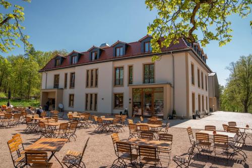 a group of tables and chairs in front of a building at Waldhotel Hohe Sonne Eisenach in Eisenach