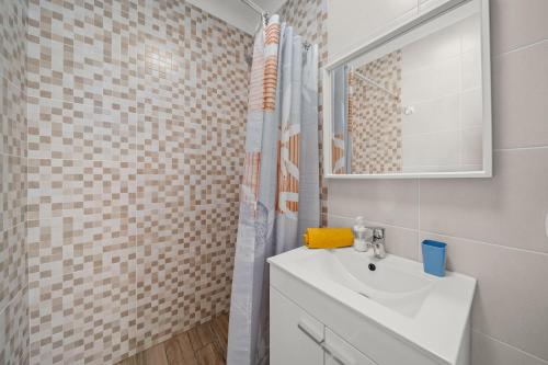 a bathroom with a white sink and a shower at Casa Sol in Praia do Carvoeiro