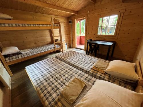 a bedroom with two beds in a wooden cabin at Vaibla Holiday Center in Vaibla