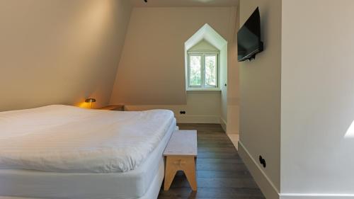 a bedroom with a bed and a tv on the wall at Bakkumer Strand in Castricum