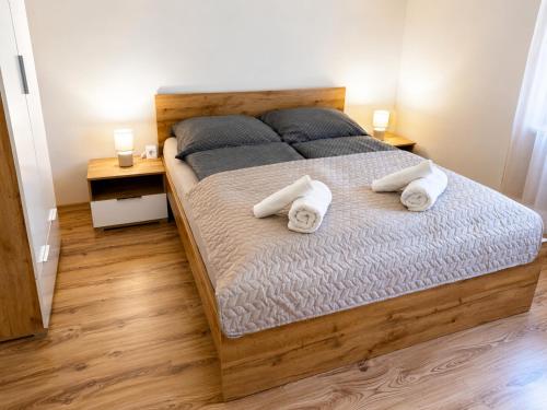 a bedroom with a bed with two towels on it at Tildy Apartman Pécs in Pécs
