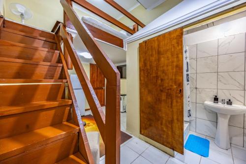 a bathroom with a wooden staircase and a sink at The 196 City Lodge in Pretoria