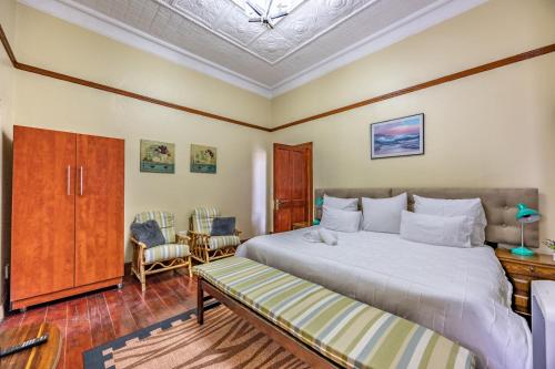 a bedroom with a bed and a table and chairs at The 196 City Lodge in Pretoria