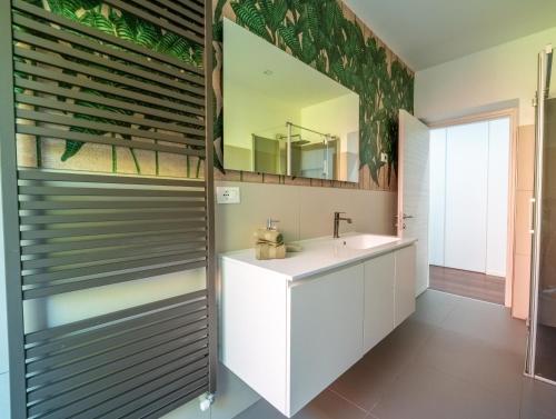 a bathroom with a sink and a mirror at Hotel Aurora & Appartamenti in Nago-Torbole