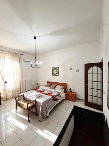 a bedroom with a large bed and a chandelier at Casa bea in Taranto