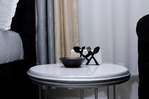 a small white table with a bowl of food on it at JS Urban Stays in Gatunga