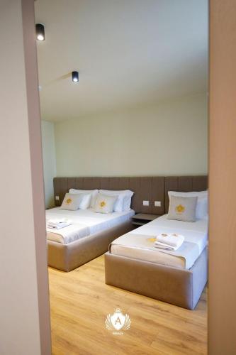 two beds in a room with a mirror at Hotel Kraja in Golem
