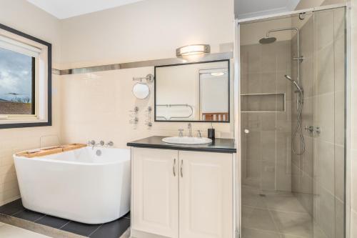 a bathroom with a tub and a sink and a shower at Leopold holiday home in Leopold