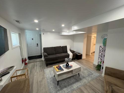 a living room with a couch and a table at Silverado Suite Modern Quiet 2BR Queen's Downtown in Kingston