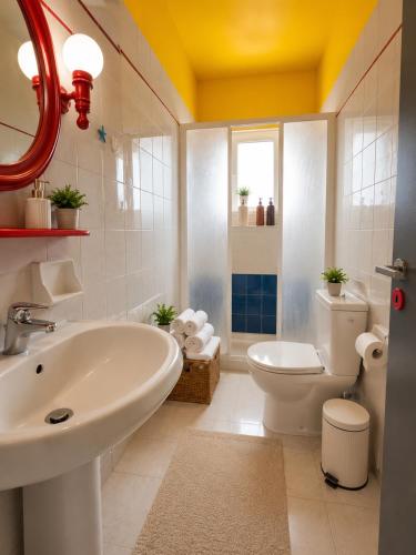 a bathroom with a white sink and a toilet at Elia Apartment Garden Oasis With Pool Astros in Paralio Astros