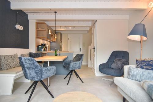 a kitchen and living room with a table and chairs at Alma & Eva, Whg 5 in Westerland
