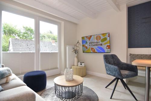 a living room with a couch and a chair and a table at Alma & Eva, Whg 5 in Westerland