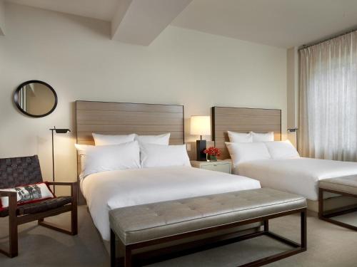 ein Hotelzimmer mit zwei Betten und einem Stuhl in der Unterkunft 21c Museum Hotel Cincinnati in Cincinnati