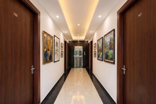 a corridor of a hallway with paintings on the walls at FabHotel Durga Luxury Studio in Gurgaon