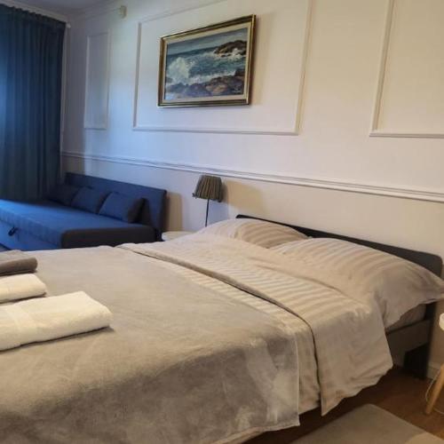 a bedroom with a bed and a blue couch at Apartamenty przy Skwerku in Sztutowo