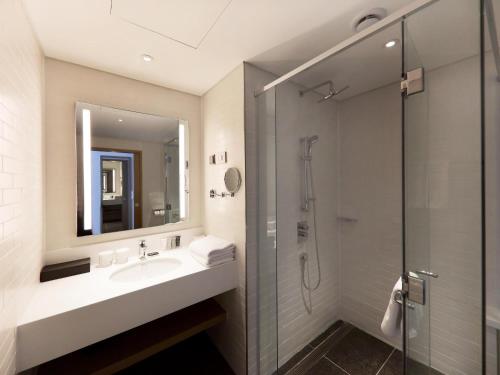 a bathroom with a sink and a shower at Mercure Ambassador Ulsan in Ulsan