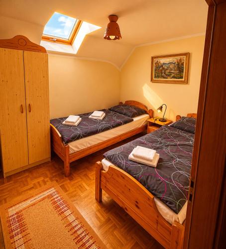 two twin beds in a room with a window at Zidanica Jakec Wine House & Scenic Views in Podlehnik