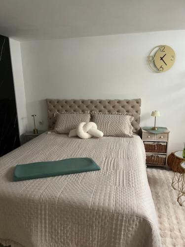 a bed with a teddy bear laying on top of it at Zeravica apartmani in Šid