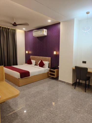 a hotel room with a bed and a desk and chair at Hotel The Crown Prince in Jaipur