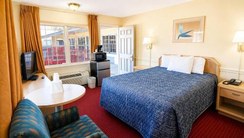 a hotel room with a bed and a tv at Captain John Smith Inn Williamsburg in Williamsburg