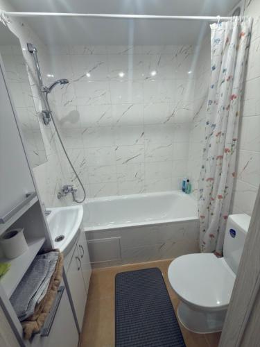 a bathroom with a tub and a toilet and a sink at Urban Place by Kelvin in Narva