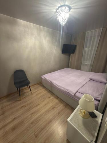 a bedroom with a bed and a chair and a table at Urban Place by Kelvin in Narva