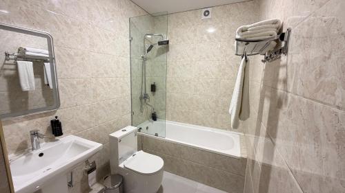 a bathroom with a toilet and a sink and a shower at Turon plaza hotel in Bukhara